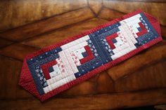 a red, white and blue quilted table runner on top of a wooden floor