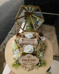 a cake that is on top of a wooden table with flowers and other things in it