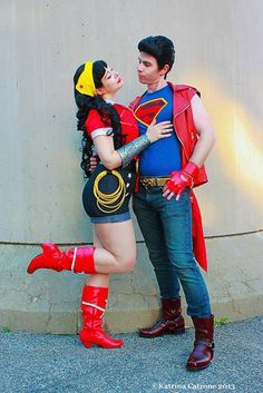 a man and woman dressed up as superman and wondergirl standing next to each other