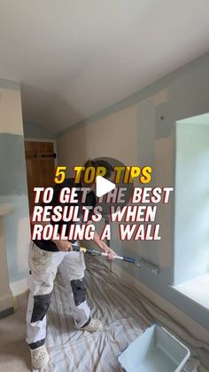 a man is painting the walls in his room with paint rollers and a bucket