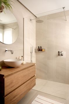 a bathroom with a sink, mirror and bathtub next to a shower head mounted on the wall