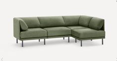 a green couch with a footstool sitting on it's backrests