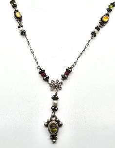 Boho multi Gemstone Garnet citrine peridot tribal sterling silver vintage necklace. Good used condition with little to no signs of normal wear. Great patina present. Stamped 925 on the back of the pendant and the clasp. Unique decorated S clasp has a citrine cab in the center. Each bead is faceted gemstone which include: peridot, citrine, garnet and white pearl. Acid tests positive for sterling silver. Gemstones tested with Presidium II gemstone tester. Necklace measures 18 inches long. Pendant measures a 1 and 1/2 inch drop and 3/8ths of an inch wide. Antique Multi-stone Pendant Necklace, Vintage Citrine Gemstone Jewelry, Antique Silver Jewelry With Natural Stones, Silver Long Necklace With Stones, Bohemian Yellow Gemstone Jewelry, Silver Bohemian Citrine Jewelry, Bohemian Sterling Silver Stone Necklaces, Antique Yellow Gemstone Jewelry, Antique Silver Citrine Jewelry