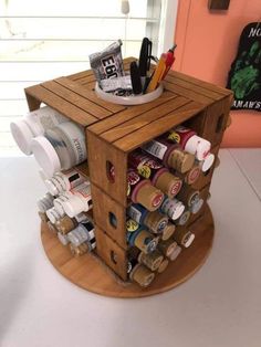 a small wooden box filled with lots of bottles and other items on top of a table