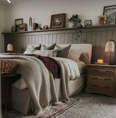 a bedroom with a bed, nightstands and pictures on the wall above it is shown