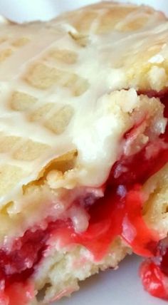 a close up of a waffle sandwich on a white plate with strawberries and cream