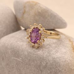 "This princess Diana ring features a natural oval cut amethyst in a halo ring surrounded by natural diamonds. This vintage Diana ring has simply an amazing contrast of colors, the purple and the gold together are simply beautiful! Perfect as an engagement ring, anniversary gift, statement ring and just as a stacking ring. * Center Stone: Clear Amethyst 7.00 x 5.00 m\"m (Approx 0.7ct) * Side Diamonds: 0.20ct, 14 Pieces * Bottom Band Thickness: 2.35 m\"m * Material: High Quality Solid Gold 14k/18k Luxury Timeless Purple Rings, Luxury Timeless Amethyst Wedding Ring, Luxury Classic Oval Amethyst Ring, Gold Ring Purple Stone, Luxury Oval Amethyst Birthstone Ring, Purple Engagement Ring Vintage, Purple And Gold Ring, Purple Diamond Ring Engagement, Purple Stone Engagement Rings