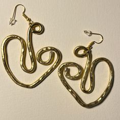 In this singular object, approximately 8 cm long and 7 cm wide, I wanted to stylize two hearts and the silhouette of two swans. The gold-coloured recycled aluminum wire has an original thickness of 3 mm and then decreases randomly after cold hammering. Aluminum, in addition to being a recycled material, gives an extraordinary lightness to the object while maintaining its characteristics of geometric compactness. I recommend avoiding scratching them, do not wear them in the pool, at the seaside o Two Swans, Two Hearts, The Seaside, Wire Earrings, Geometric Earrings, Favorite Jewelry, Jewelry Earrings Dangle, Hippie Boho, Gold Color