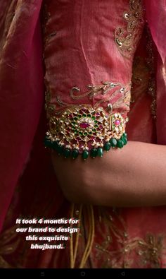 a close up of a person wearing a pink dress and bracelet with green beads on it