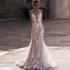 a woman in a wedding dress is standing on the street with her back to the camera