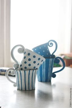 two blue and white coffee cups sitting on top of a table next to each other