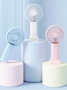 three different types of mini - fan sitting on top of each other in front of a blue wall