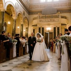 a bride and groom walking down the aisle at their wedding ceremony in an ornate building