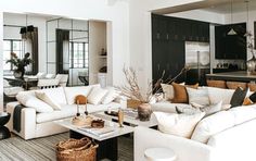 a living room filled with white furniture and lots of pillows on top of couches