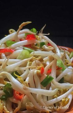 a bowl filled with noodles and vegetables on top of a table