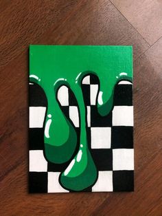 a green and black checkered painting on wood