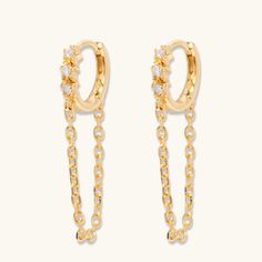 Bring edge and style to any look with these Sienna Huggie Hoops! These ultra-chic earrings feature an edgy yet stylish hoop design that's perfect for any occasion. flaunt your unique style with these fabulous must-haves! We cannot stop wearing these on repeat here at L&T headquarters! Features: 18k gold plated Sterling Silver 12mm in diameter 1 inch drop Cubic Zirconia Hinge post closure Trendy Huggie Earrings For Party, Party Dangle Huggie Earrings, Party Huggie Dangle Earrings, Trendy Gold Plated Dangle Hoop Earrings, Party Huggie Hoop Earrings, Tarnish Resistant Small Hoop Earrings For Party, Hoop Design, Chic Earrings, On Repeat