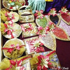 many plates and bowls are decorated with red ribbons, poinsettis and bows