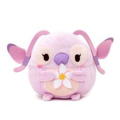 a pink stuffed animal with big ears and large eyes, holding a flower in it's mouth