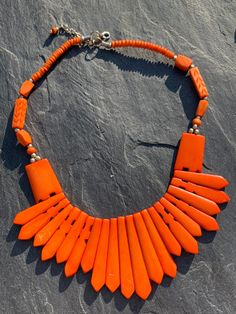 Vintage Orange/Coral tribal looking necklace. Not sure of the material of this could be made from a type of bone/coral, almost 99% it's coral, can't stretch out the necklace fully due to the shape and cut of the front beads, they are entirely natural as you can see the natural cut of the  beads.  Very striking one to be noticed in! Trigger lobster claw clasp in silver effect metal which I think has been added at a later date, has metal spacer beads incorporated into the necklace. It is a really Bohemian Orange Red Coral Beads, Orange Bohemian Red Coral Beads, Orange Red Coral Beaded Necklaces Hand-strung, Unique Orange Red Coral Necklace, Hand-strung Orange Necklace, Types Of Bones, Vintage Orange Metal Necklace, Unique Hand-strung Orange Necklace, Coral Beads Necklace