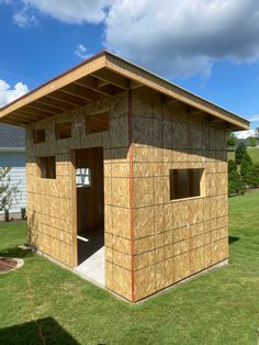 a small wooden building sitting on top of a lush green field