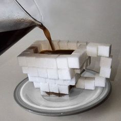 someone is pouring coffee into a small cube shaped object made out of marshmallows