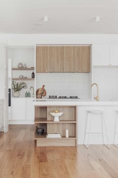 a kitchen with wooden floors and white walls