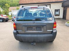 the back end of a grey suv parked in a driveway