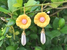 "These beautiful hibiscus earrings were created with brass lace settings adorned with yellow and pink hibiscus flowers and Vintage teardrop glass pearls. These floral earrings hang beautifully from the ear and measure 2 1/2 inches in length and measure 3/4 inches in width at widest point. These earrings make the \"perfect gift\" for your mom, sister, daughter, friend, girlfriend, wife or bridesmaids....She will truly love these and treasure them for many years to come. ~All of my listings are ha Elegant Yellow Dangle Flower Earrings, Elegant Yellow Flower Shaped Earrings, Elegant Yellow Flower-shaped Earrings, Handmade Yellow Flower Earrings For Wedding, Yellow Flower Drop Earrings For Wedding, Yellow Flower Earrings For Wedding, Yellow Earrings With Ear Wire For Wedding, Yellow Ear Wire Earrings For Wedding, Yellow Wedding Earrings With Ear Wire