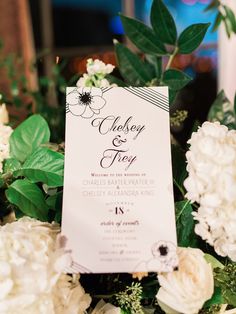 a close up of a table with flowers and a sign on it's side