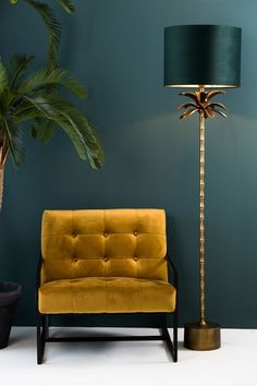 a living room with green walls and a yellow chair next to a tall palm tree