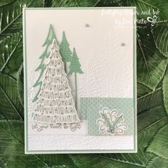 a handmade christmas card with green leaves and a white tree on it, in the middle