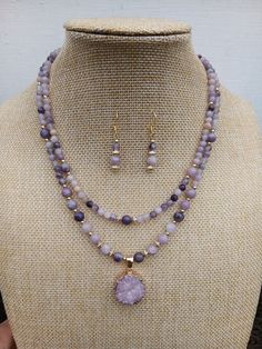 Purple mauve shades necklace and earrings set. Its  colours will give special warm summer feeling. Item Details Genuine 6-4 mm lepidolite round beads combined with 18k gold plated jewellery findings, 18k gold filled 3-4mm round beads. Drizzy quartz pendant as a center piece. Necklace 18-16" length.  Pendant  W 0.75" H 0.75" Earrings 1.25" in length, 18k gold plated over sterling silver hooks.  Please be aware that each product is handmade and unique. Materials Genuine Lepidolite, 18k gold filled Multi-strand Jewelry With 108 Beads As Gift, Lavender Round Jewelry With Faceted Beads, Elegant Lavender Crystal Necklace With Round Beads, Purple Double Strand Natural Stones Jewelry, Purple Double Strand Jewelry With Natural Stones, Double Strand Purple Jewelry With Natural Stones, Elegant Lavender Beaded Necklace With Natural Stones, Double Strand Amethyst Gemstone Beads Jewelry, Purple Multi-strand Gemstone Beads Jewelry