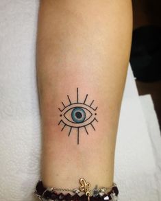 a woman's arm with an evil eye tattoo on it