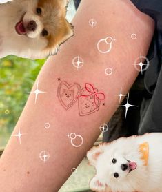 two small dogs sitting next to each other near a woman's leg with tattoos on it