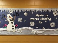 a bulletin board with music is worth melting for the snowman and musical notes on it