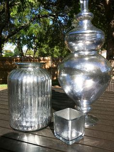 two glass vases sitting on top of a wooden table