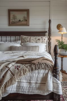 a bedroom with a bed, nightstands and pictures on the wall above it is shown