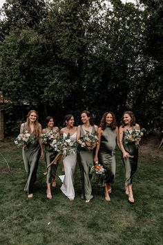 Bridesmaids in mismatched satin green bridesmaid dresses with the bride in a satin slip wedding dress Bridesmaid Dresses Garden, Mismatched Green Bridesmaid Dresses, Sage Green Bridesmaid Dresses, Olive Bridesmaid Dresses, Sage Green Bridesmaid, Olive Green Bridesmaid Dresses, Garden Wedding Bridesmaids, Bridal Parties Colors, Olive Green Weddings