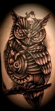 an owl tattoo on the back of a woman's thigh, with a clock in it