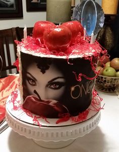 a cake decorated with an image of a woman's face and apples on top