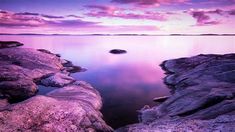 the water is calm and clear as it sits on some rocks