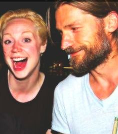 a man and woman are laughing together at a party in front of the camera with their mouths open