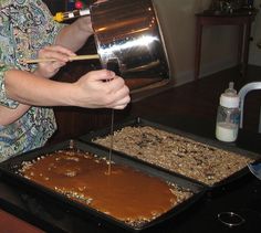 a woman is spreading peanut butter on top of a cake in a pan with a spatula