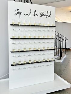 there is a sign that says sip and be seated next to some glasses with wine in them