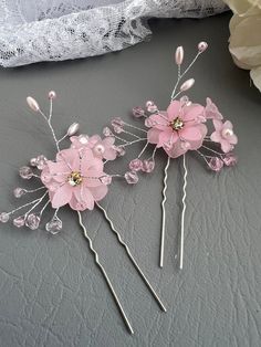 Beautiful set of 2 soft pink acrylic set of flowers decorated with rhinestones, pink rice pearls and pink glass beads, that is set on a silver hair pin.   Measures approximately 4 1/4 inches long and 2 1/2 wide. Set of 2 Pink Flower Hair, Silver Hair Pin, Acrylic Set, Pink Bride, Bride Hair Accessories, Pink Acrylics, Pink Glass, Silver Hair, Bride Hairstyles