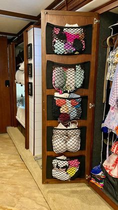 a closet filled with lots of clothes next to a wall covered in hanging bags and shoes