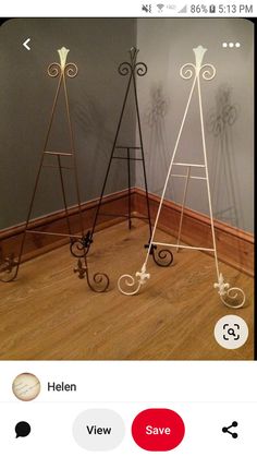 two metal easels sitting on top of a wooden floor