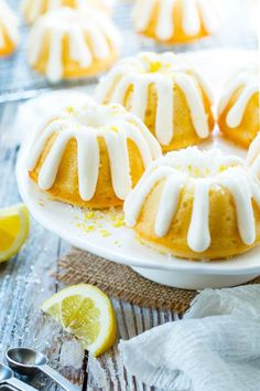 lemon bundt cakes with icing on a white plate next to sliced lemons