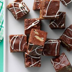 chocolate brownies with white icing on a plate